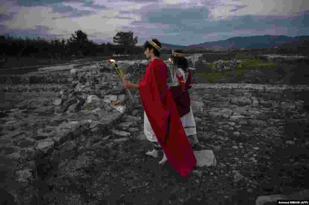 A couple dressed as ancient Roman citizens hold torches during a performance of Justinian And Theodora at the Ulpiana Festival near Pristina on September 17. The two-day festival held at the Ulpiana archaeological site offers participants a rare glimpse of life in antiquity with performers, food stalls, games, dance, and handicrafts.