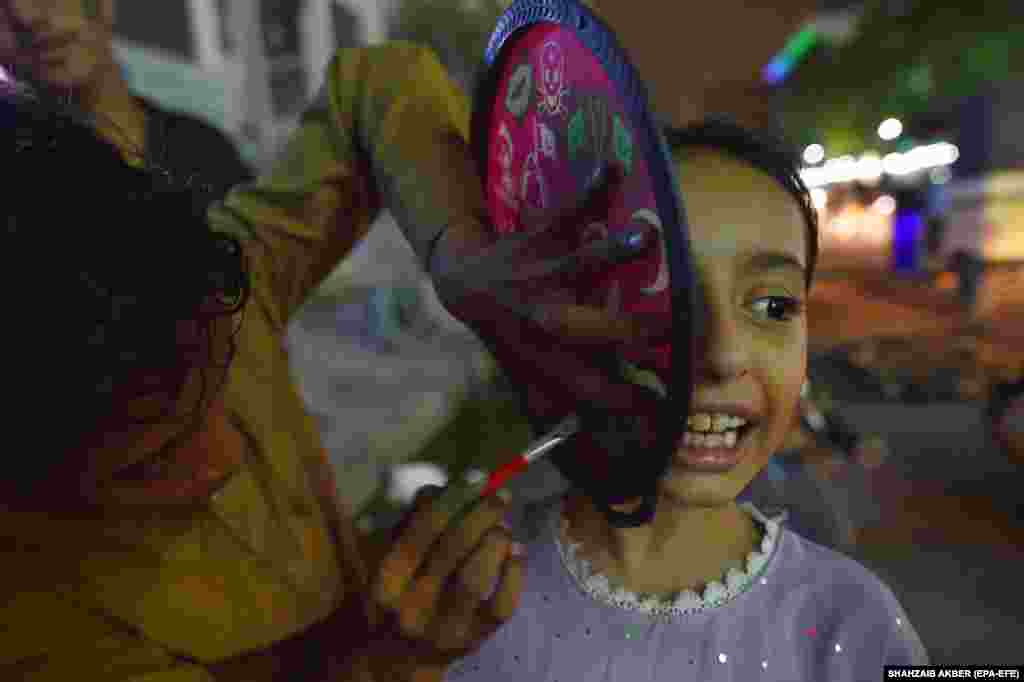 A girl has a national flag painted on her face ahead of Independence Day celebrations in Karachi, Pakistan.