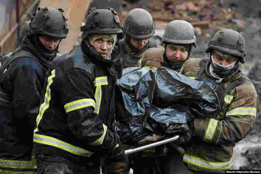 Rescuers carry the body of Iryna Osadcha, the 55-year-old director of a local museum who was killed by a Russian missile strike in Kupyansk, Kharkiv region, Ukraine.