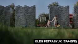 Látogatók a háborús bűnök áldozatainak emlékművénél a Kijev melletti Bucsában 2023. szeptember 17-én