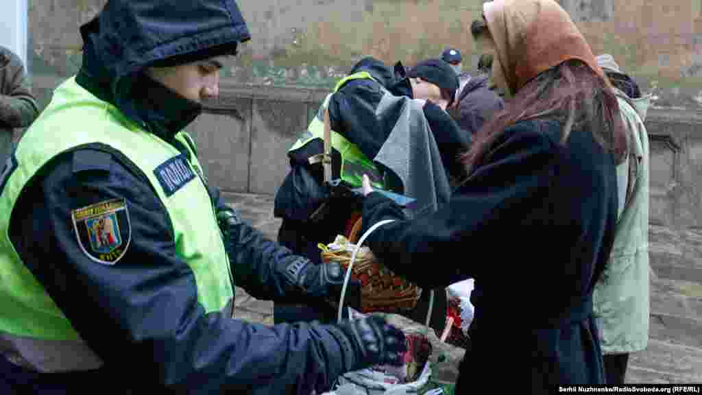 Поліцейські перевіряють кошики вірян перед тим, як пустити їх на територію Лаври