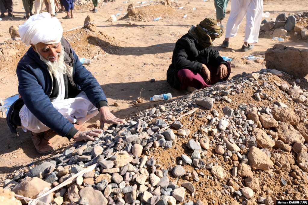 Le persone in lutto si siedono accanto alle tombe dopo le preghiere funebri per i loro parenti.  Oltre al WFP, squadre dell'Organizzazione mondiale della sanità (OMS) delle Nazioni Unite si sono precipitate nelle zone di Herat più colpite dai terremoti.  I dipendenti dell'OMS sono già sul campo per aiutare a salvare e curare le persone ancora sotto le macerie, ha detto a RFE/RL la filiale afghana dell'organizzazione.