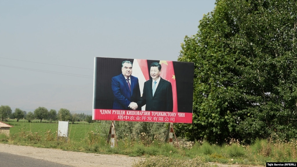 A sign showing Chinese leader Xi Jinping (right) and Tajik President Emomali Rahmon outside the entrance of a Chinese-Tajik agricultural project in Yovon in May 2023.