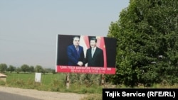 A sign showing Chinese leader Xi Jinping (right) and Tajik President Emomali Rahmon outside the entrance of a Chinese-Tajik agricultural project in Yovon in May 2023.