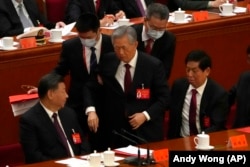 Bivši predsednik Kine Hu Đintao pod pratnjom mimo svoje volje odlazi s kongresa Kineske komunističke partije, dok aktuelni lider Si Đinping gleda sa strane, Peking, 21. oktobar 2022.