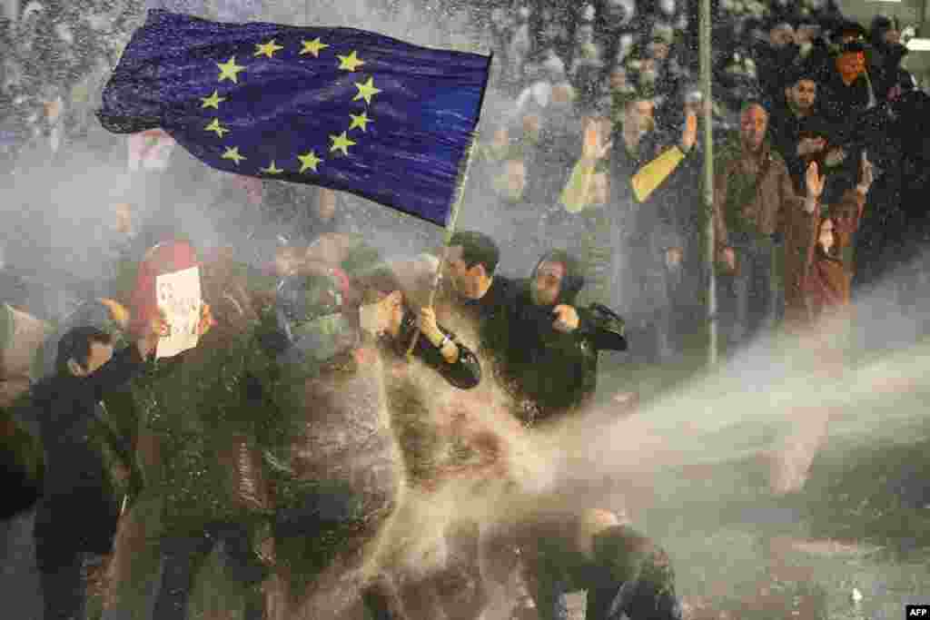 Протестувальників, які тримають прапор ЄС, поливають із водометів під час протесту у Тбілісі 7 березня 2023 року. Верховний представник ЄС із закордонних справ назвав законопроєкт &laquo;дуже поганим розвитком&raquo; для цієї кавказької країни