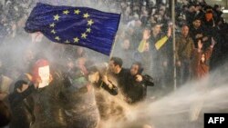 Протестующих, держащих флаг ЕС, поливают из водометов во время протеста в Тбилиси 7 марта 2023 года