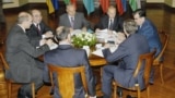This June 2004 photo is one of first images in existence of a meeting of the heads of the Collective Security Treaty Organization&nbsp;(CSTO) military alliance.<br />
<br />
The image shows (left to right) Presidents Alyaksandr Lukashenka of Belarus, Askar Akaev of Kyrgyzstan, Nursultan Nazarbaev of Kazakhstan, Vladimir Putin of Russia, Emomali Rahmon&nbsp;of Tajikistan, and Secretary-General Nikolai Bordyuzha (with back to camera on right) and President Robert Kocharian of Armenia (back to camera in foreground) during a meeting of the CSTO in Astana, Kazakhstan.