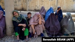 Women wait to receive food from foreign aid in Kandahar, Afghanistan, on August 10.