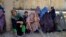 Women wait to receive food from foreign aid in Kandahar, Afghanistan, on August 10.