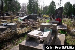 Tombstones lie shattered from shelling in Yatseve Cemetery.