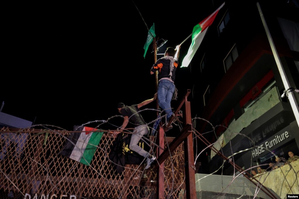 Protestuesit libanezë me flamuj palestinezë  ngjiten në rrethojën e Ambasadës së SHBA-së, në Bejrut, Liban, pasi qindra palestinezë u vranë në një shpërthim në spitalin Al-Ahli në Gaz më 17 tetor 2023. 