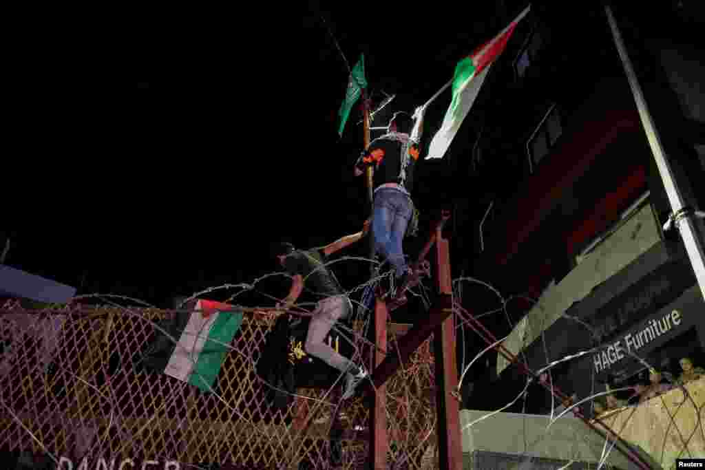 Protestuesit libanezë me flamuj palestinezë&nbsp; ngjiten në rrethojën e Ambasadës së SHBA-së, në Bejrut, Liban, pasi qindra palestinezë u vranë në një shpërthim në spitalin Al-Ahli në Gaz më 17 tetor 2023.&nbsp;