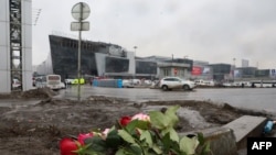 Flori lăsate la locul atacului armat la sala de concerte Crocus City Hall din Krasnogorsk, lângă Moscova, pe 23 martie 2024.