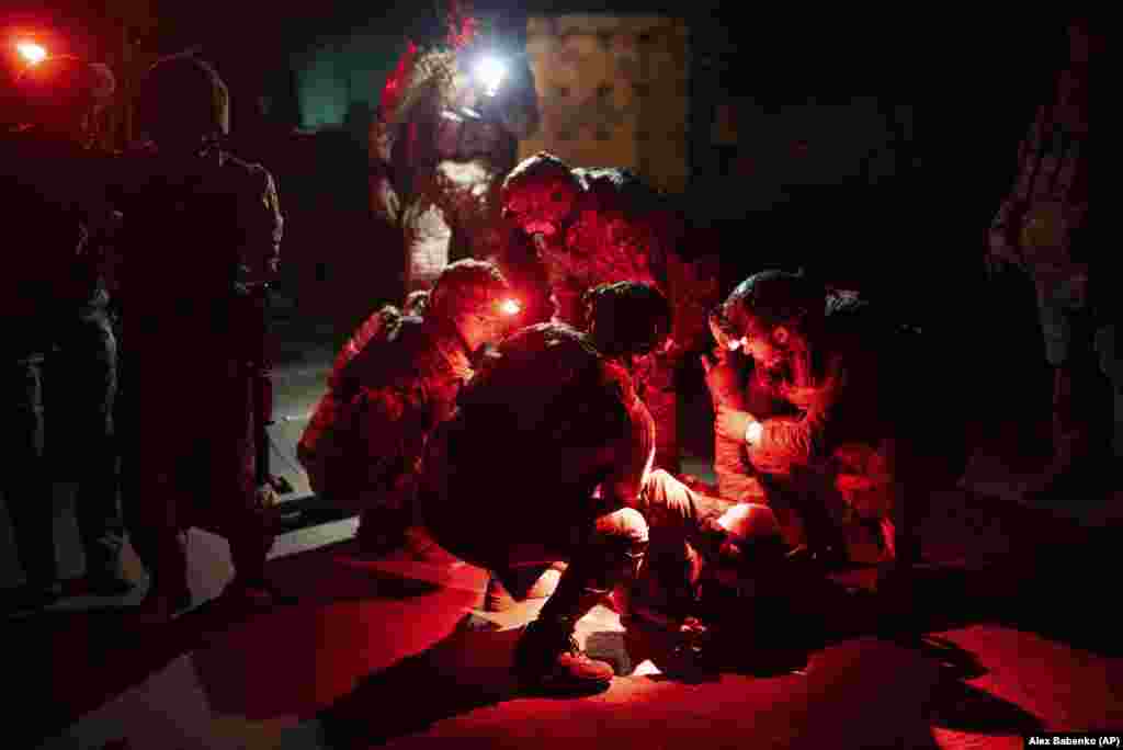 Ukrainian paramedics from the 3rd Assault Brigade move a wounded comrade to an evacuation ambulance near Bakhmut.