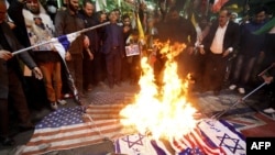 Iranians burn Israeli and U.S. flags during a protest at Palestine Square in Tehran on April 1.