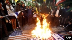 Iranianët duke djegur flamuj izraelitë dhe amerikanë gjatë një proteste të mbajtur në Teheran, më 1 prill.
