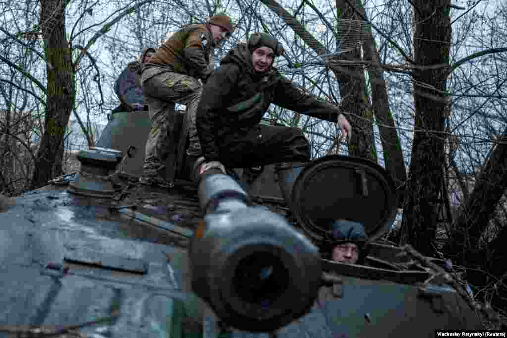 Украинские солдаты садятся на самоходную гаубицу 2С1 &laquo;Гвоздика&raquo; перед её выходом на огневую позицию