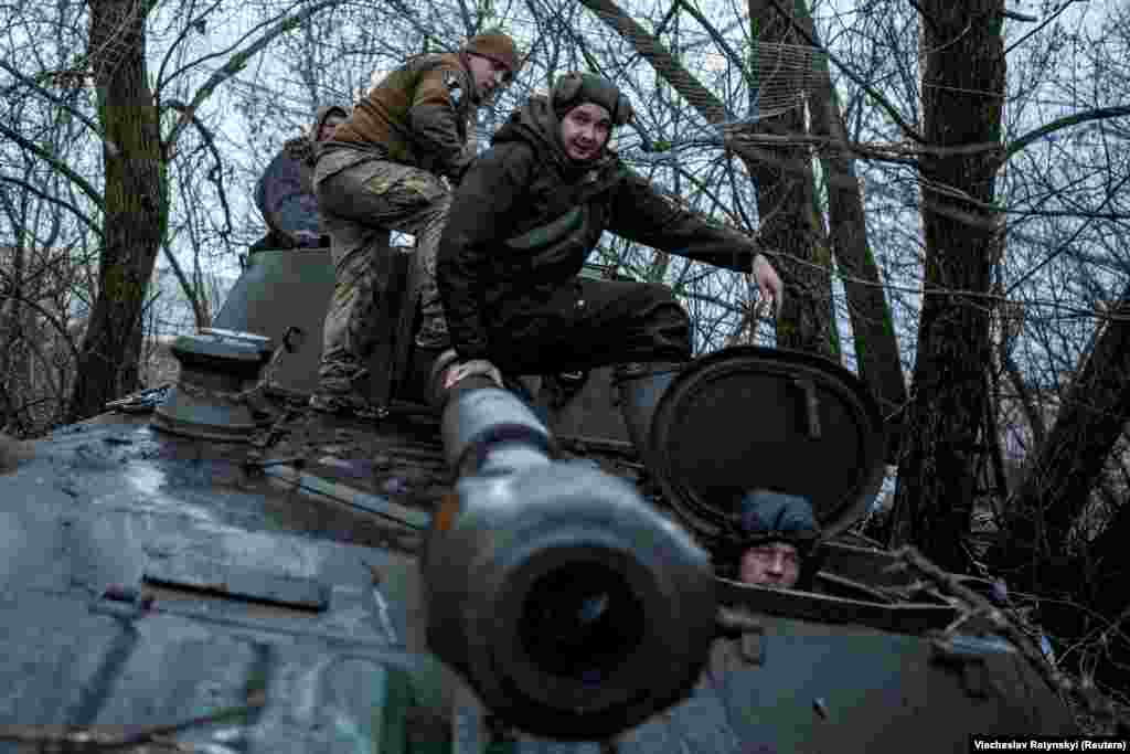 Ushtarët ukrainas hipin në tankën vetëlëvizëse 2S1 Gvozdika, para se të kalojë në pozicionin e qitjes.