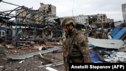Ukrajinski vojnik hoda u blizini stambenih zgrada oštećenih granatiranjem, Bahmut 23. april 2023.