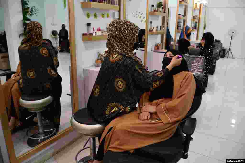 An Afghan beautician applies makeup to a client at a beauty salon in Mazar-e Sharif on July 5. Afghanistan&#39;s Taliban authorities have ordered beauty parlors across the country to shut within a month, the vice ministry confirmed on July 4, the latest curb to squeeze women out of public life.