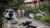 Localnici stau lângă blocul lor avariat de un atac cu rachete rusești, Kiev, 30 august 2023