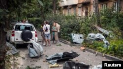 Localnici stau lângă blocul lor avariat de un atac cu rachete rusești, Kiev, 30 august 2023