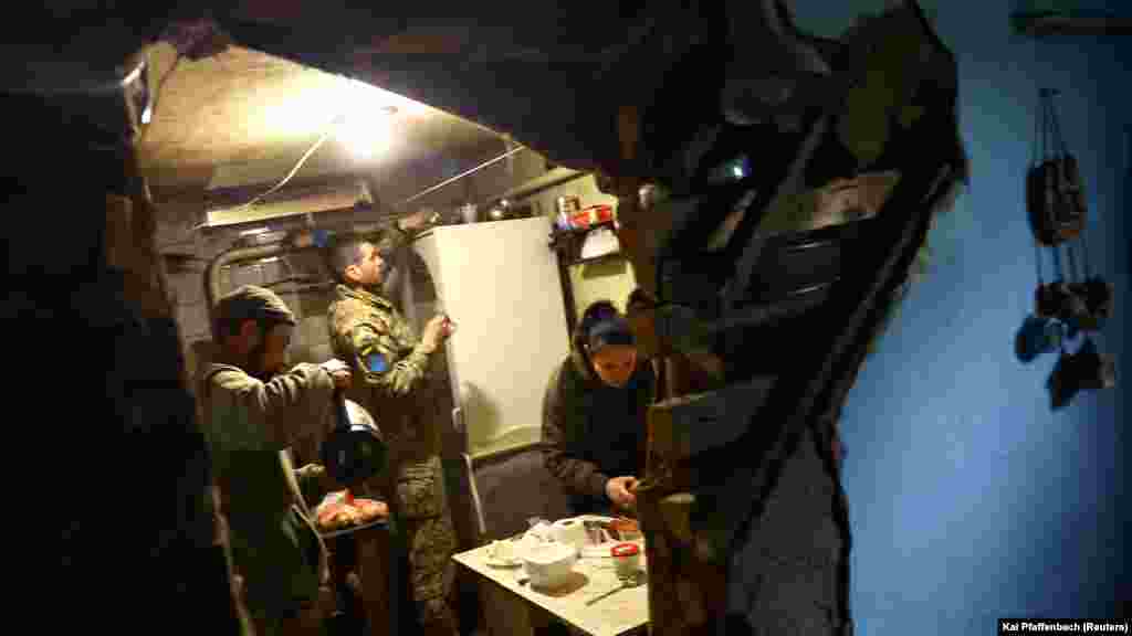 Ukrainian soldiers prepare meals in their hideout. &nbsp;