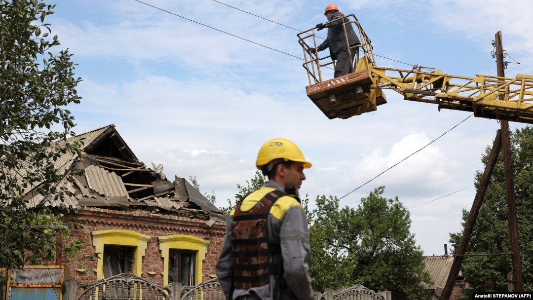 Electricienii Companiei de Energie DTEK refac rețeaua electrică deteriorată de atacurile rusești asupra unui sat din apropierea liniei de front din regiunea Donețk, pe 23 iulie 2024.