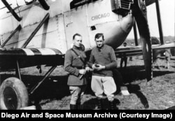 Руководитель экспедиции Лоуэлл Смит (справа) и механик Лесли Арнольд на фоне самолёта «Чикаго». Четыре самолёта были названы в честь американских городов