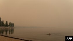 Sara Sokoloski pliva u jezeru Okanagan prekrivenom dimom od šumskih požara, Vest Kelouna, Kanada, 19. avgust 2023.