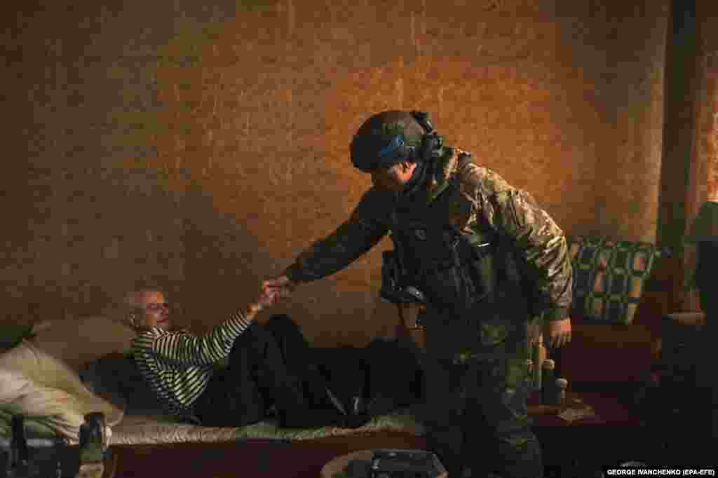 A Ukrainian police officer helps Viktor, an 84-year-old disabled man, during evacuations from the town of Vovchansk in the Kharkiv region.&nbsp;