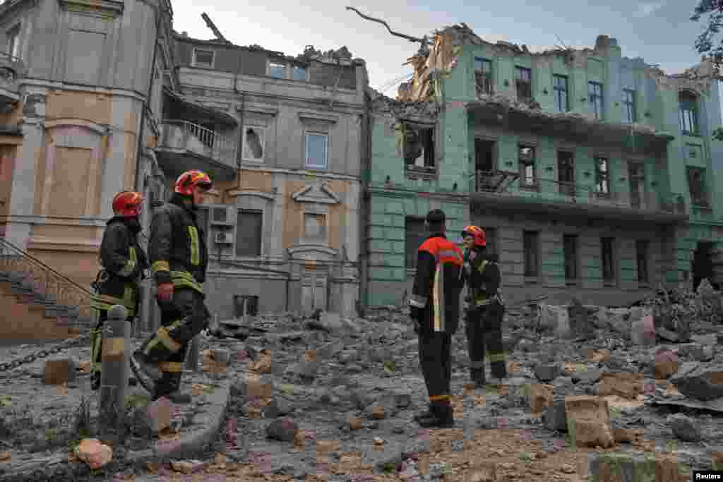 Salvatorii stau în fața clădirilor rezidențiale avariate în timpul atacurilor cu rachete rusești, pe fondul atacului Rusiei asupra Ucrainei, la Odesa, Ucraina 23 iulie 2023