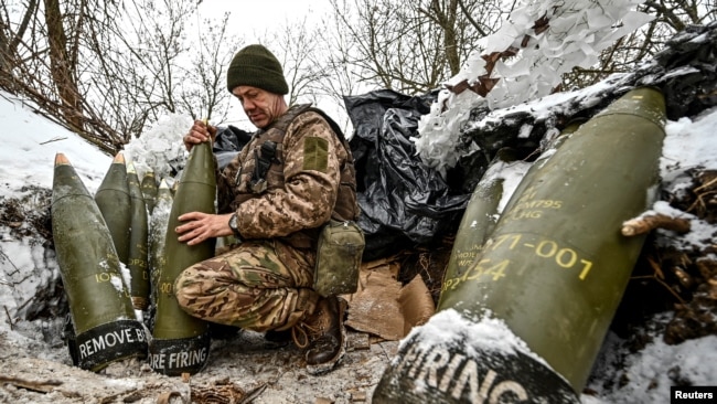 Украински войник подготвя 155 мм снаряди близо до фронтовата линия, 14 януари 2024 г.