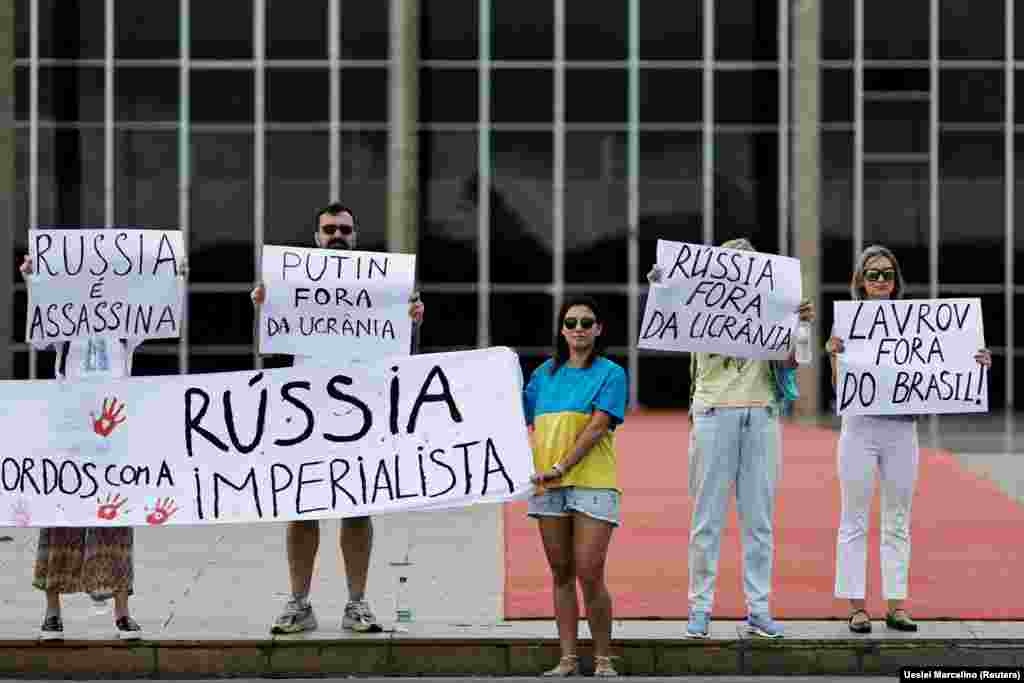 Бразиліа. Люди тримають плакати, протестуючи проти візиту міністра закордонних справ Росії Сергія Лаврова до Бразилії та на підтримку України