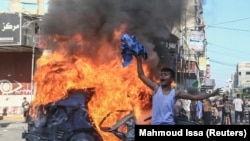 Палестинско момче на фона на горяща кола