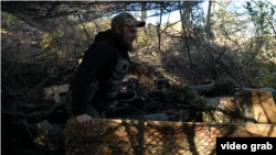Военнослужащий ВСУ маскирует пушку М777 в Херсонской области