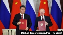 Chinese President Xi Jinping (left) and Russian President Vladimir Putin attend a signing ceremony following their talks at the Kremlin in Moscow on March 21.