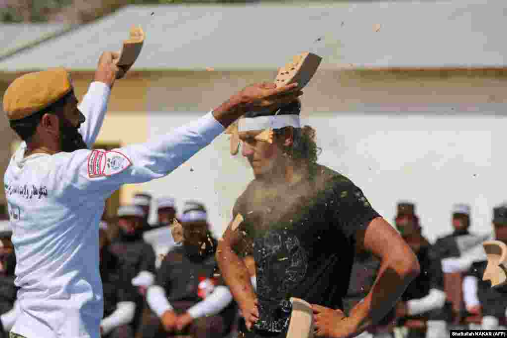 A newly recruited Taliban fighter demonstrates his strength at a graduation ceremony in Jalalabad, Afghanistan.