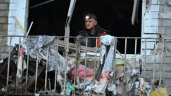 A resident clears debris from his apartment in a residential building damaged as a result of Russian strikes in Kharkiv on March 27.