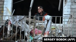 A resident clears debris from his apartment in a residential building damaged as a result of Russian strikes in Kharkiv on March 27.