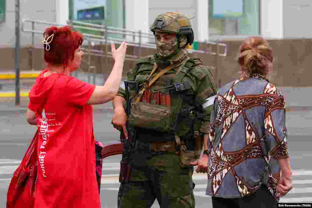 A woman speaks to an armed man in Rostov-on-Don after exiting a bus.&nbsp; &nbsp;