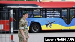Натовський автобус з написами «Озброюйте Україну» та «Поки ви чекаєте на цей автобус, Україна чекає на F-16», припаркований біля місця проведення саміту НАТО у столиці Литви. Вільнюсі 11 липня 2023 року 