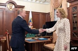 Russian President Vladimir Putin and Children's Rights Maria Lvova-Belova, both wanted for arrest by the ICC, meet at the Kremlin on March 9, 2022.