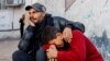 Dy palestinezë të mërzitur për personat e vrarë në një sulm izraelit në Rafah të Gazës.

