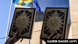 Protestuesit palestinezë qëndrojnë me kopje të Kuranit, librit të shenjtë të Islamit, gjatë një proteste jashtë selisë së konsullatës suedeze në lagjen Sheikh Jarrah të Jeruzalemit Lindor, më 3 korrik 2023.