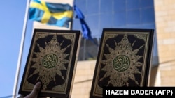 Palestinski demonstranti stoje s kopijama Kur'ana, islamske svete knjige, tokom demonstracija ispred sjedišta švedskog konzulata u istočnojerusalemskoj četvrti Sheikh Jarrah 3. jula 2023. 