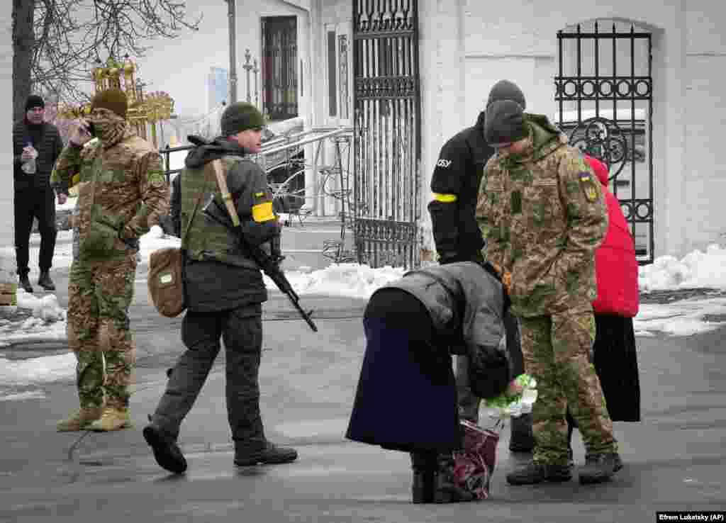 Ukrainian security officers search the bags of a woman at the lavra on November 22, 2022. The monastery complex was raided by the authorities soon after a video surfaced on November 12, 2022 showing worshipers inside the church singing a patriotic Russian song that ended with a line: &ldquo;The ringing [of church bells] are floating, floating over Russia, Mother Russia is awakening.&rdquo;