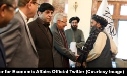The Afghan Taliban's acting deputy prime minister, Mullah Baradar (right), meets a Pakistani delegation led by then-Defense Minister Khwaja Asif (left) in Kabul in February.