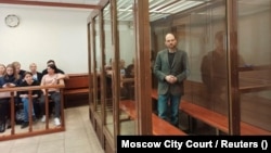 Vladimir Kara-Murza stands inside an enclosure for defendants during a court hearing in Moscow on April 17.